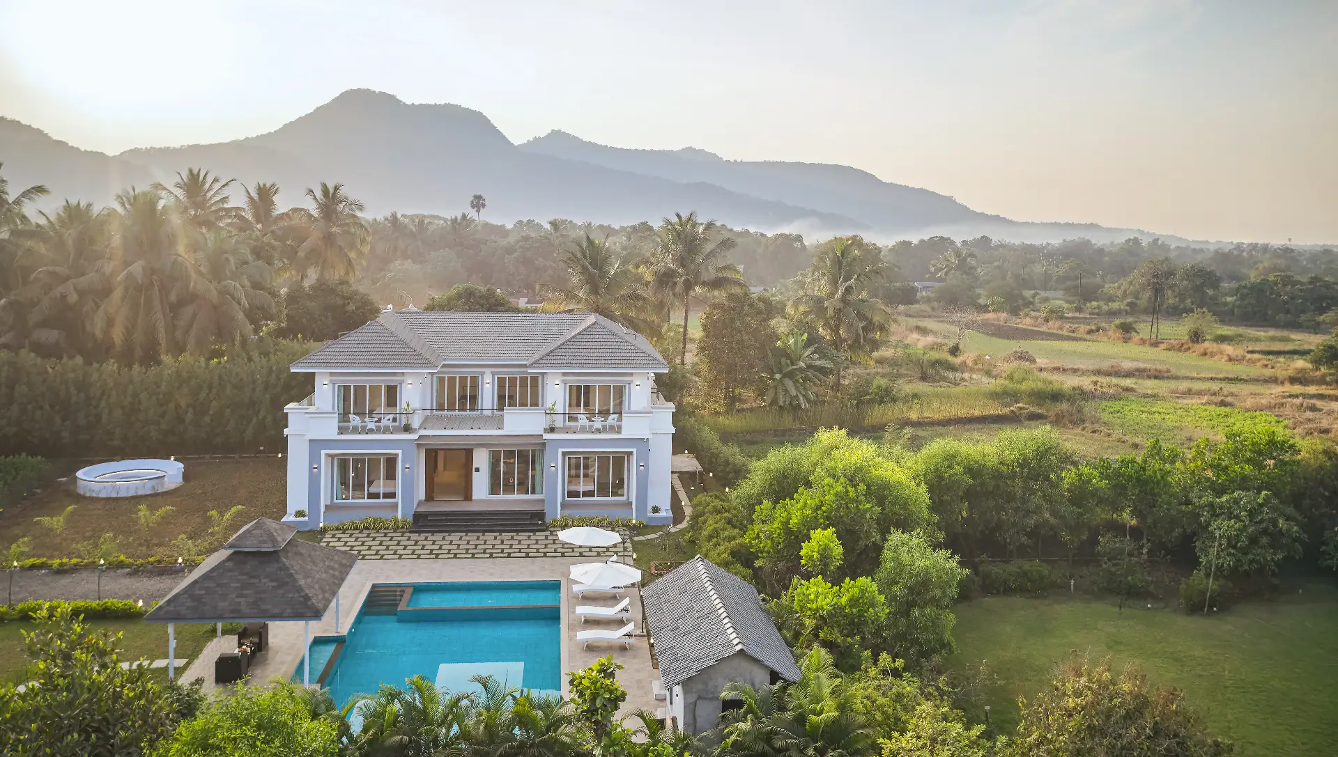 A modern Privy Stays villa nestled in lush nature with mountains at sunrise